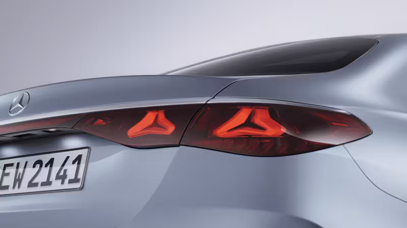 Mercedes-Benz Blick auf silbernes Fahrzeug von hinten mit leuchtenden Heckleuchten