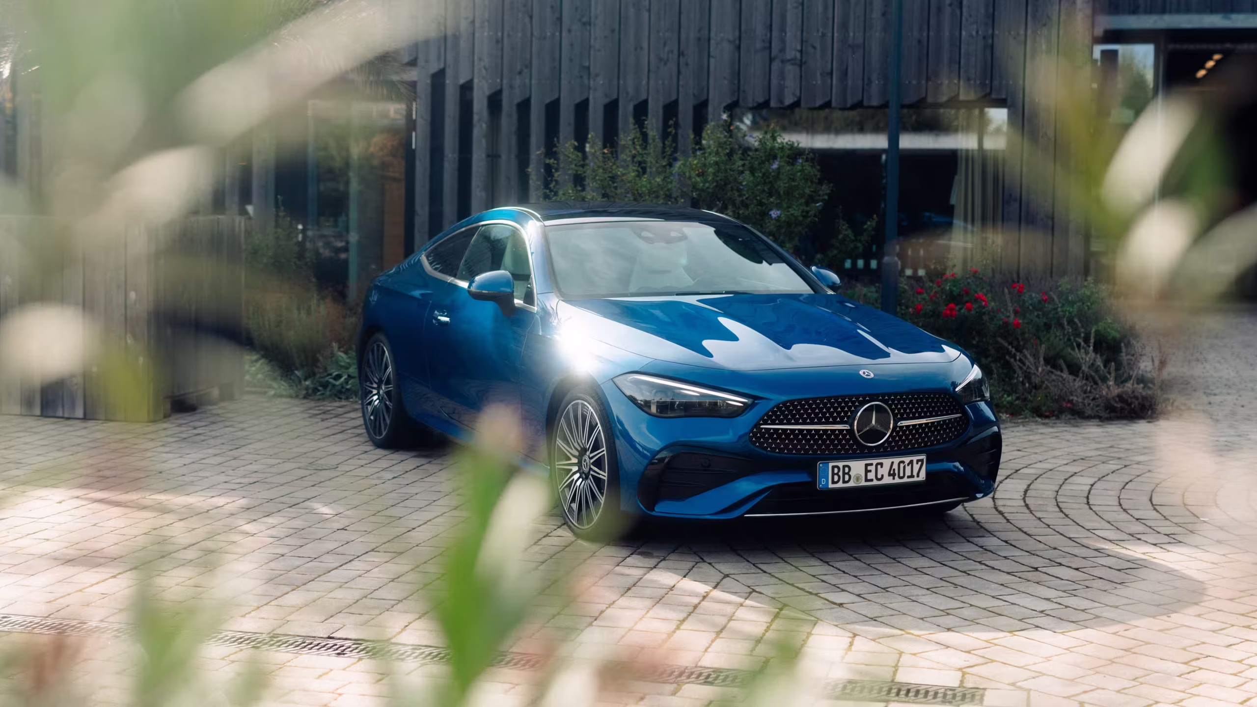 S-Klasse in blau steht auf einem Hof vor einem modernen Haus