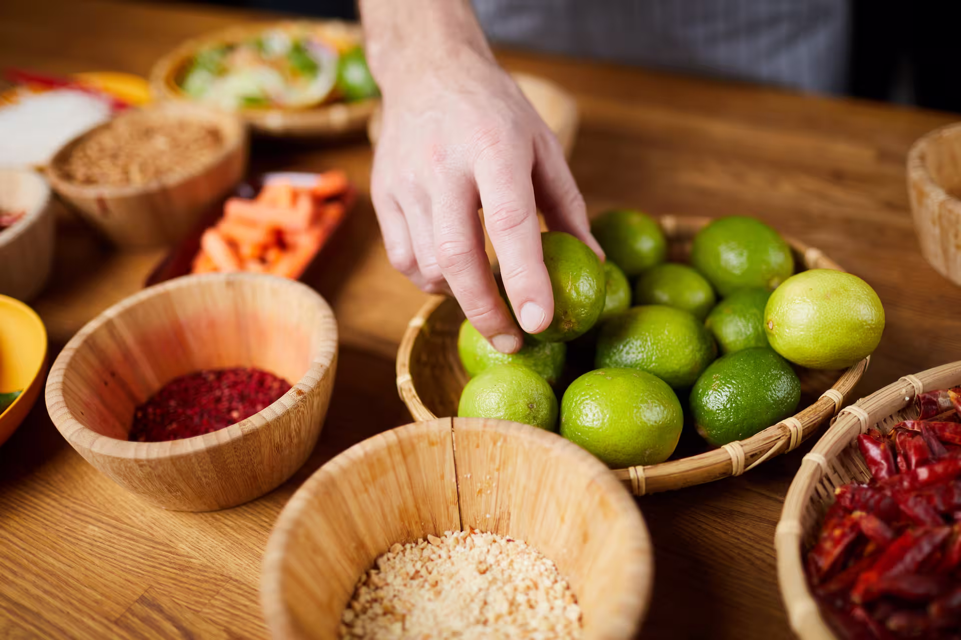 Männliche Hand nimmt sich vom Tisch eine Limette